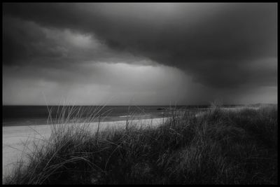 Scenic view of sea against cloudy sky