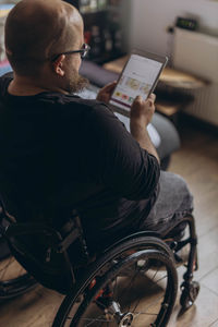 Rear view of man using mobile phone