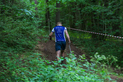 Rear view of man walking in forest