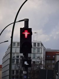 Low angle view of road sign against sky in city