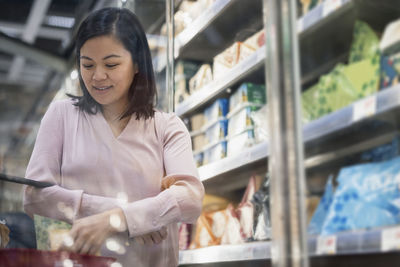 Young woman shopping during inflation in supermarket