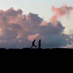 Silhouette couple standing against sky during sunset