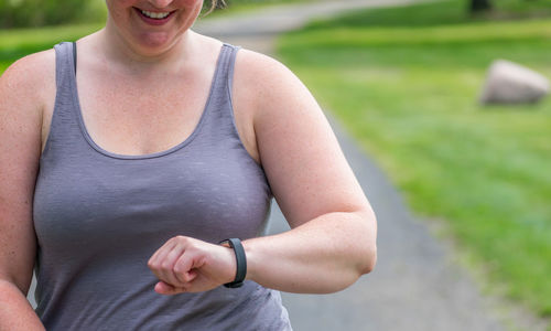 Midsection of smiling woman checking the time