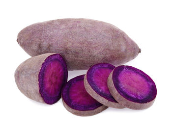 Close-up of purple fruits against white background