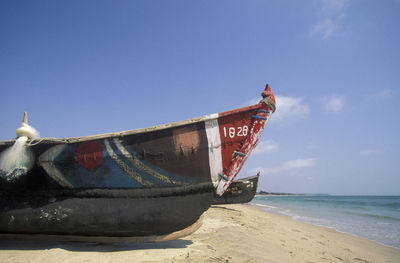 Boat moored on beach against clear sky