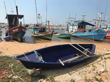 Boats moored at harbor against sky