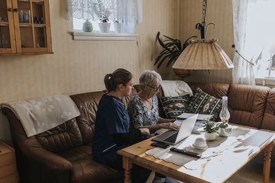 Home caretaker helping senior woman with bills