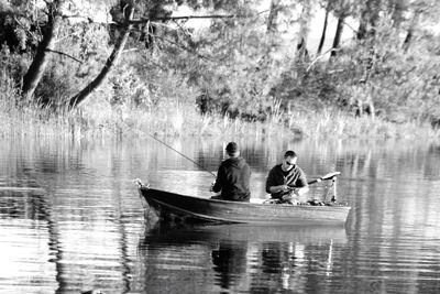 People sitting on boat in lake