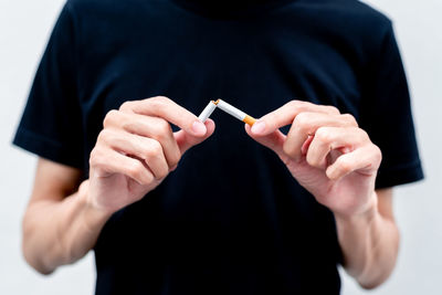 Close-up of man holding hands over black background