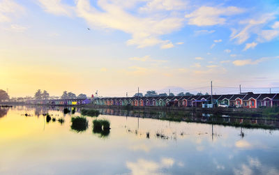 Scenic view of river by buildings against sky