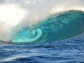 Scenic view of sea waves splashing against sky