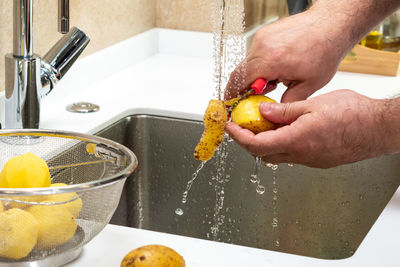 Close-up of hand washing hands in sink