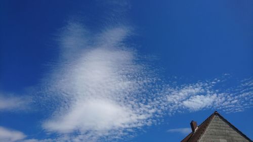 Low angle view of blue roof and building against sky