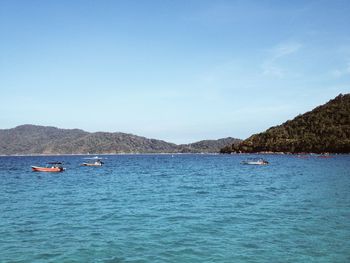 Boats sailing in sea against sky