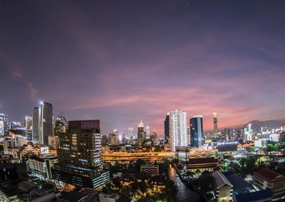 Illuminated buildings in city against sky