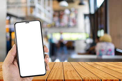 Low angle view of person using smart phone on table
