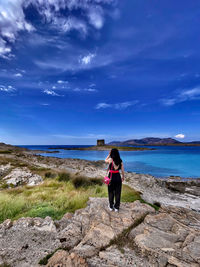 Rear view of woman looking at sea against sky