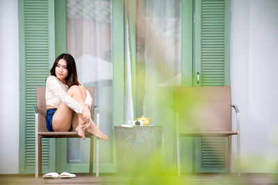 Portrait of woman sitting in window