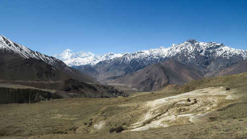 Scenic view of snowcapped mountains against clear blue sky