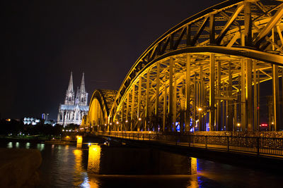 Bridge over river in city at night