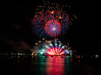 Firework display over river at night