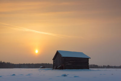 Snow covered landscape at sunset