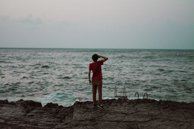 Rear view of woman standing on beach