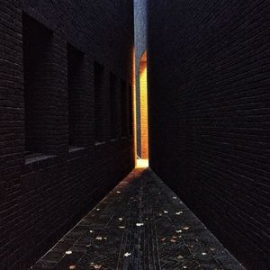 Narrow alley amidst brick wall