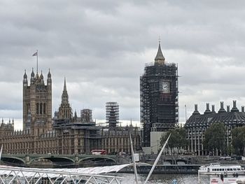 Buildings in city against cloudy sky