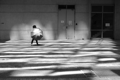 Rear view of woman walking on building