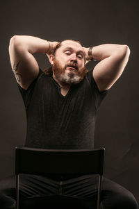 Young man looking away over black background