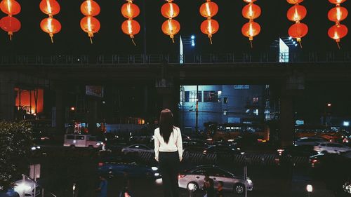 People standing on illuminated street at night
