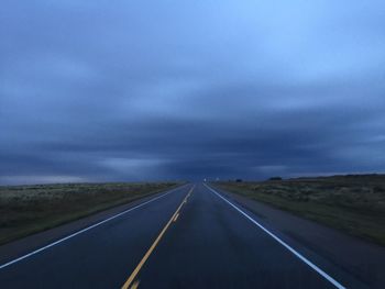 Country road against cloudy sky