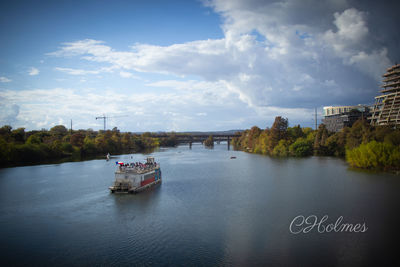 Scenic view of river by buildings against sky