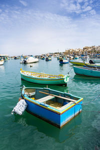 Boats moored in sea against sky