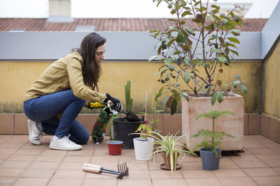 Woman sitting on potted plant