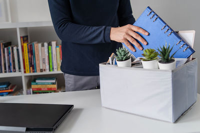 Midsection of man reading book on table