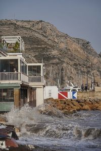 Scenic view of sea by buildings against sky