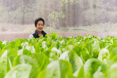 Asian woman owner standing in hydroponic organic vegetable farm.