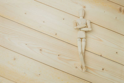 Directly above shot of figurine on wooden table