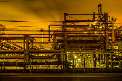 Illuminated industry against sky at night