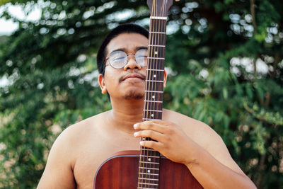 Midsection of man playing guitar