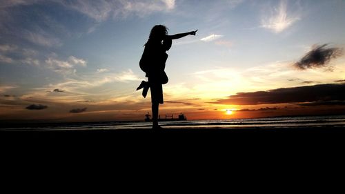 Silhouette man piggybacking woman at beach during sunset