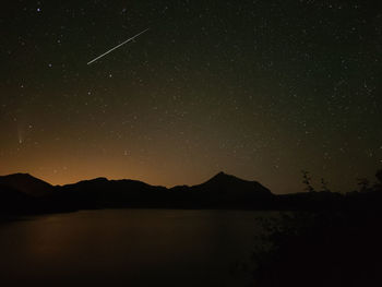 Scenic view of silhouette mountains against sky at night