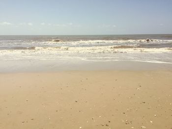 View of sandy beach against blue sky