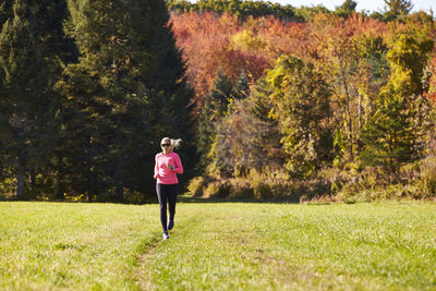 A woman running on a trail on a nice autumn day.