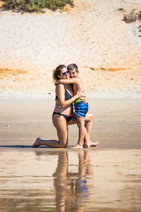 Mother and son hugging on a beach