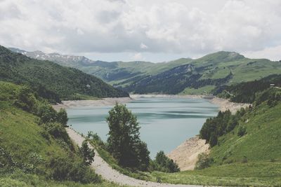 Scenic view of river and mountains against sky