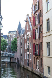 Canal amidst buildings against sky
