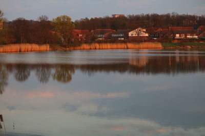 Scenic view of lake by buildings against sky